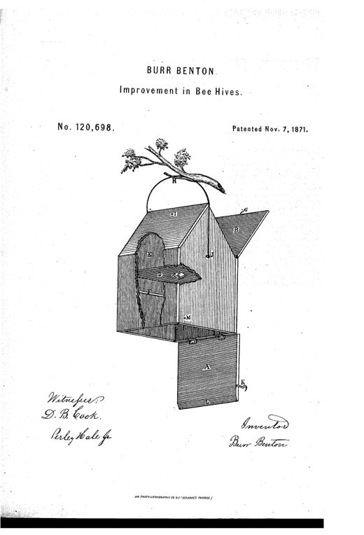 An engraving of a wooden beehive hanging by a curved bail from a tree branch, showing an angular hinged roof lid labeled B and G, a domed entrance E, an internal partition D with opening C, comb-support strips F, and a separate hinged bottom section A with hook K and staple L below the main hive body.